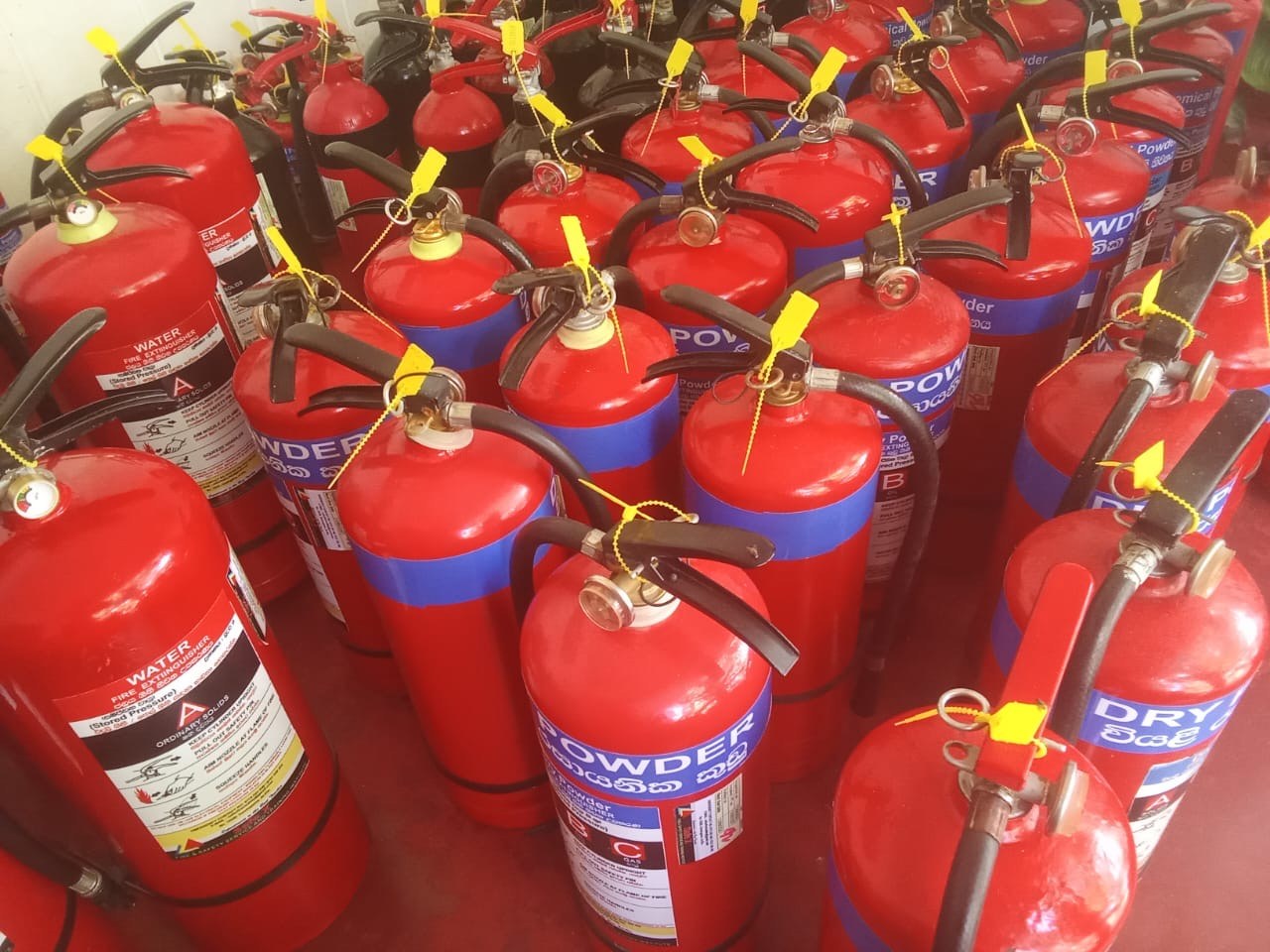 Freshly serviced and refilled dry powder fire extinguishers with tamper seals