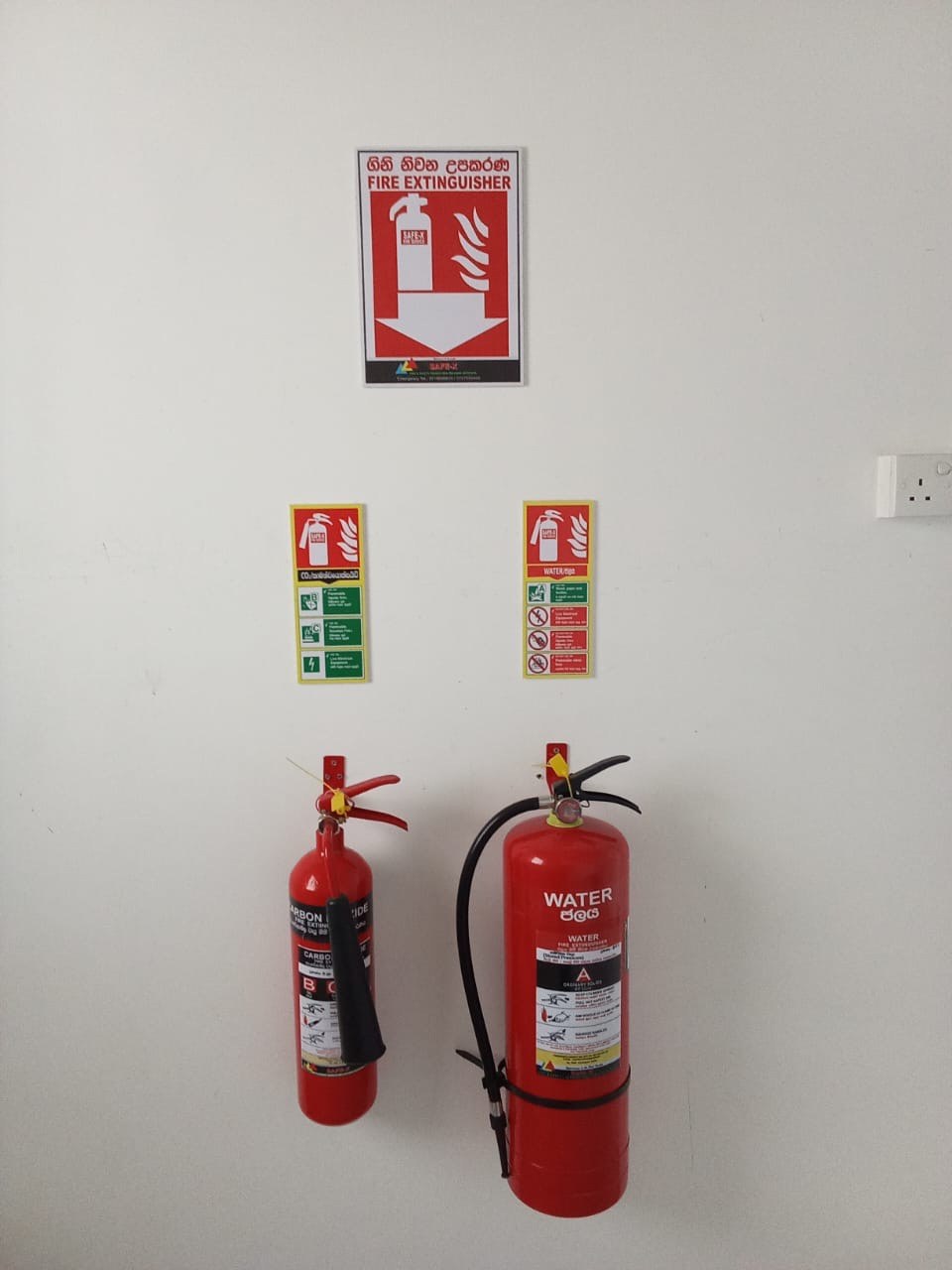Wall-bracket fire station installation with CO2 and DCP cylinders