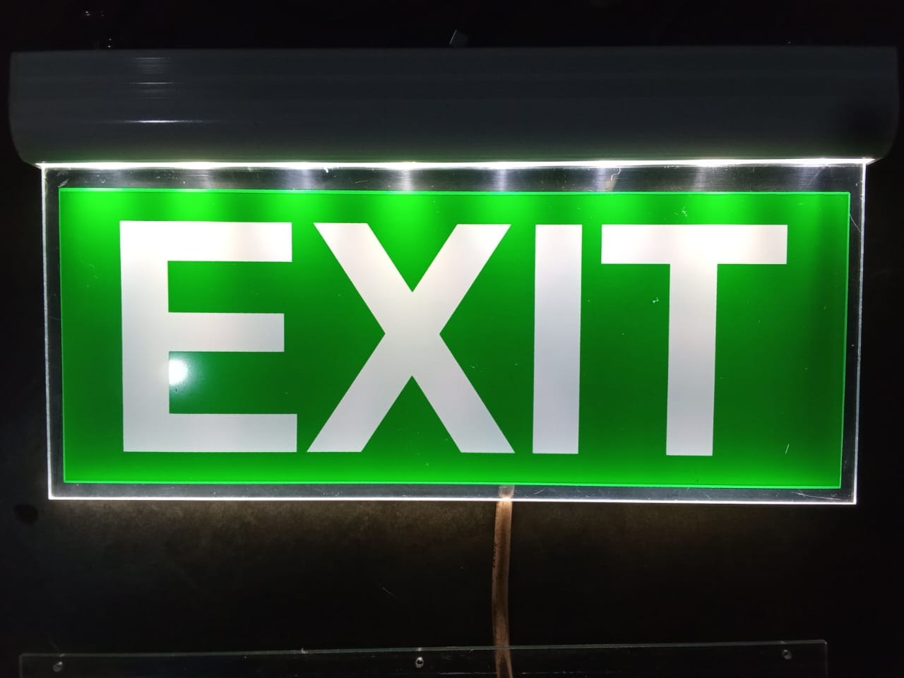 Overhead green LED illuminated fire exit sign with directional arrow