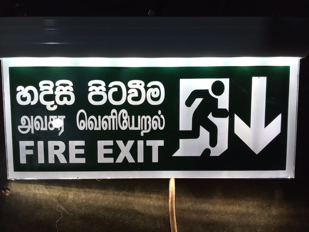 Trilingual Sinhala, Tamil, and English illuminated emergency fire exit sign
