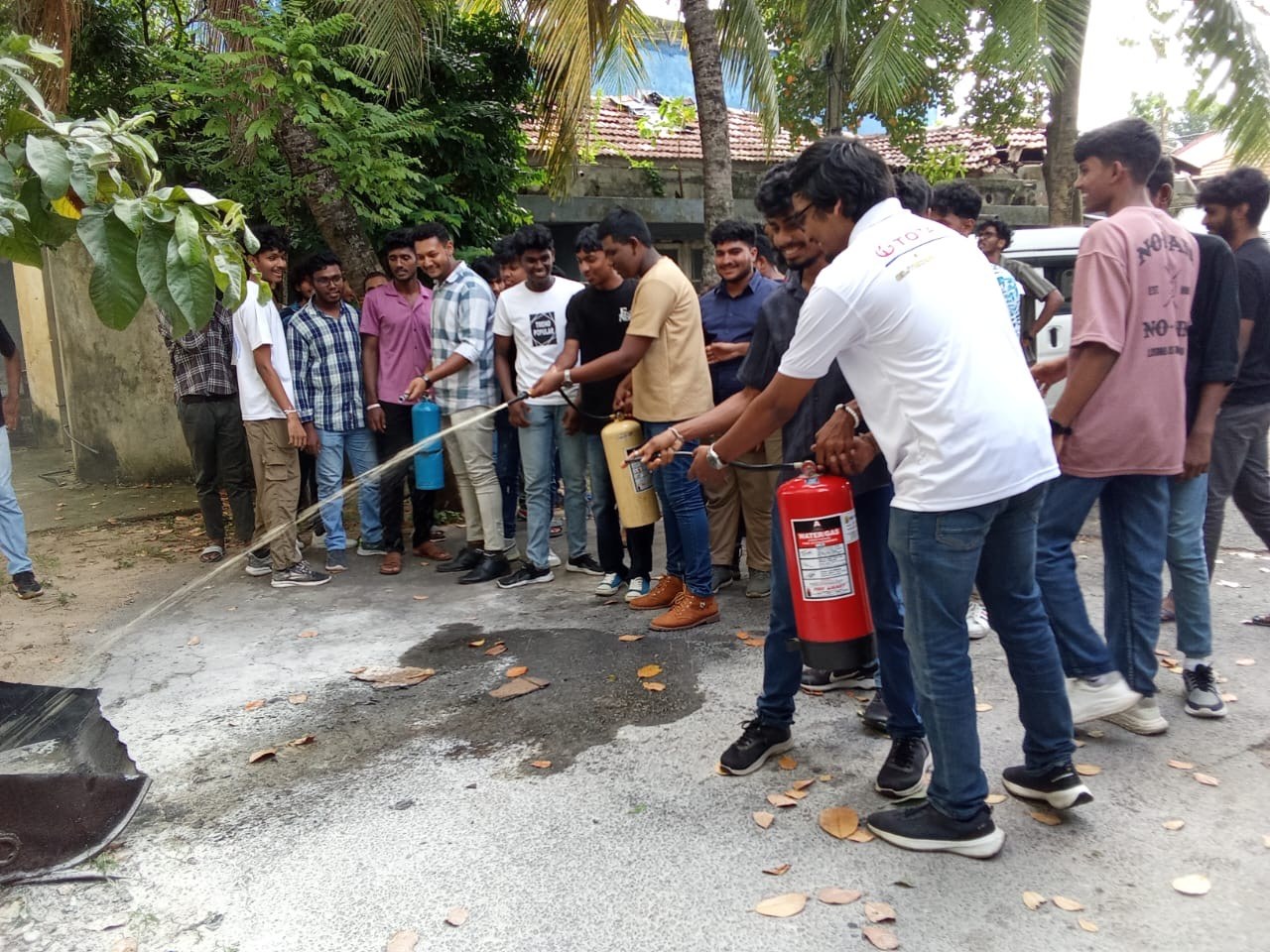 Industrial team operating pressurized fire hose reel during training