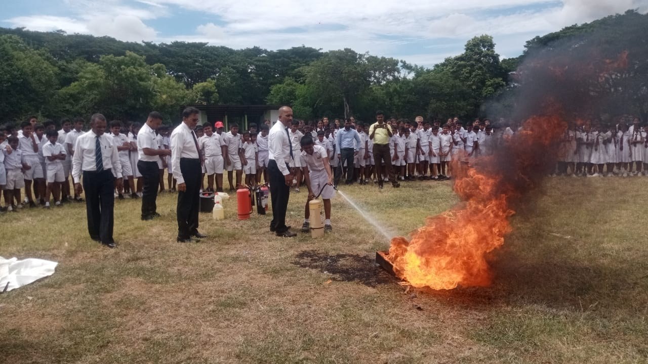 Lead instructor coaching trainee on proper fire extinguisher sweeping technique